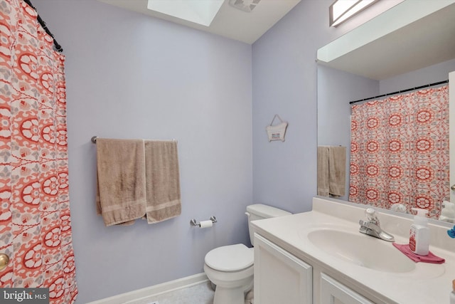 bathroom featuring a skylight, vanity, and toilet