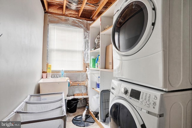 clothes washing area with stacked washer and dryer