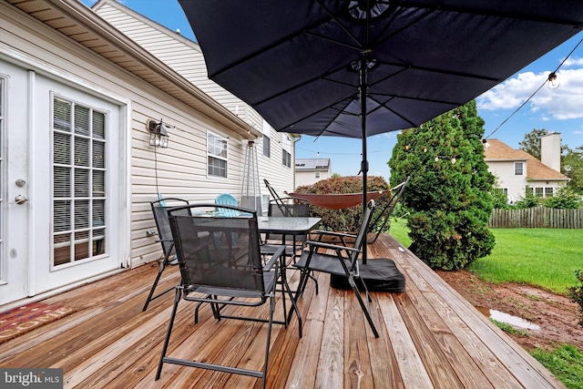 wooden terrace featuring a yard