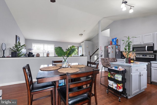 dining area featuring vaulted ceiling and dark hardwood / wood-style floors