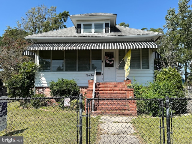 bungalow with covered porch and a front yard