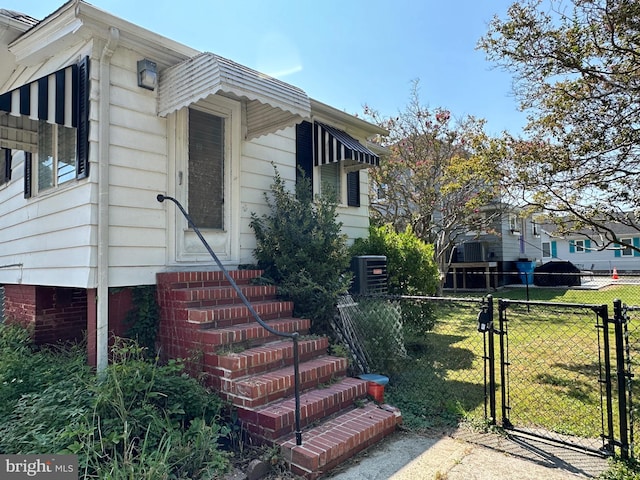 view of front facade with a front lawn and central AC