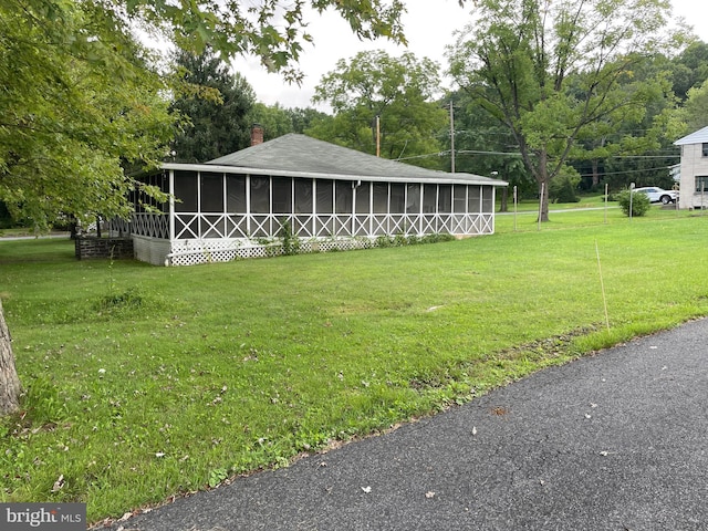 view of front of home featuring a front lawn and a sunroom