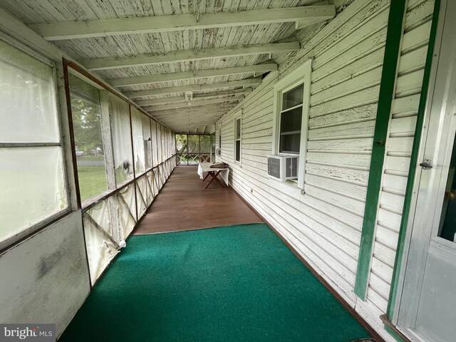 unfurnished sunroom featuring cooling unit and lofted ceiling