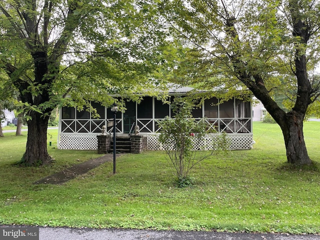 view of front of home with a front yard and a sunroom