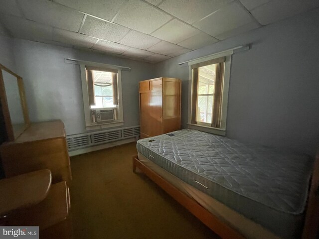 bedroom with cooling unit and a drop ceiling