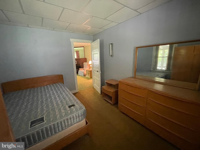 carpeted bedroom with a drop ceiling