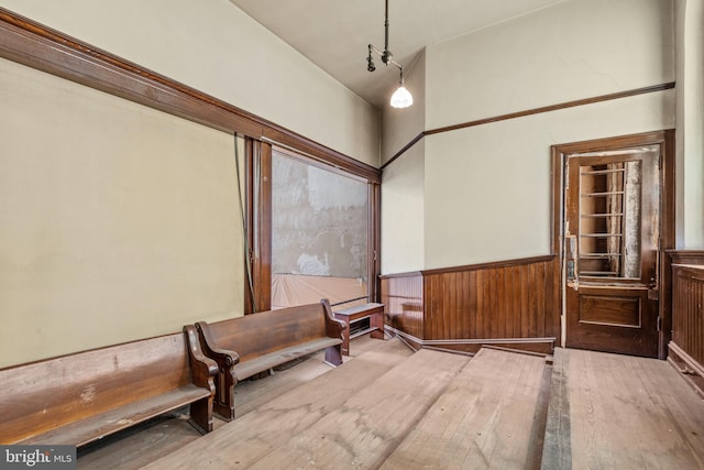 sitting room featuring a towering ceiling and wood-type flooring