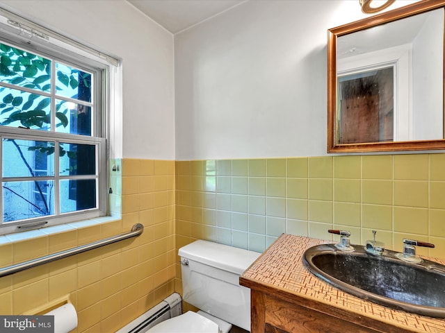 bathroom featuring tile walls, vanity, a healthy amount of sunlight, and toilet