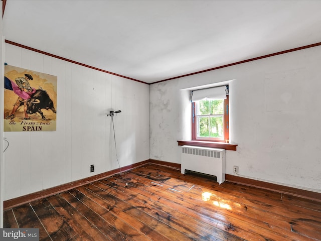 spare room with ornamental molding, hardwood / wood-style floors, and radiator