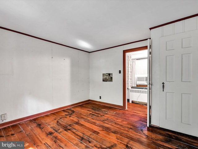 unfurnished room with wood-type flooring, ornamental molding, and radiator heating unit