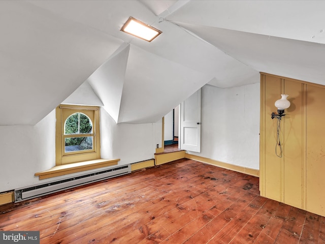 additional living space with lofted ceiling, a baseboard heating unit, and wood-type flooring