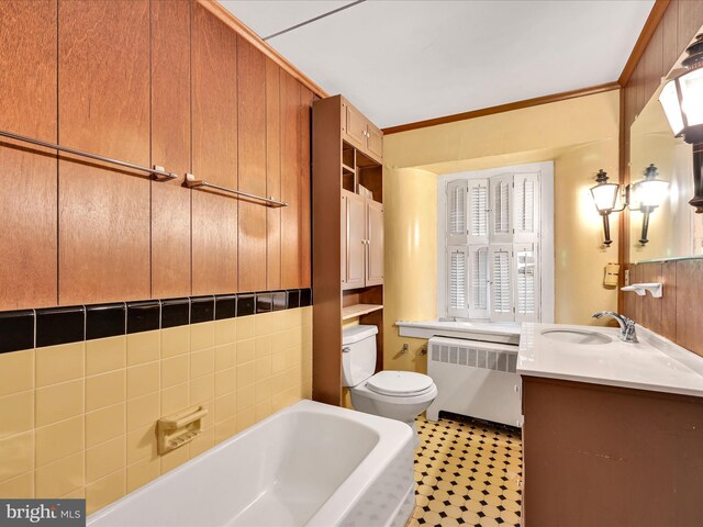 bathroom with tile patterned floors, vanity, radiator, a washtub, and toilet