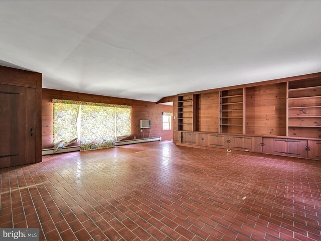 unfurnished living room with a baseboard heating unit and wooden walls