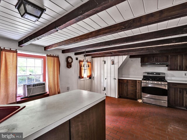 kitchen featuring beam ceiling, stainless steel gas stove, hanging light fixtures, and dark brown cabinets