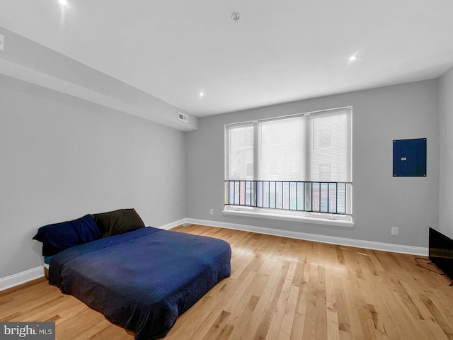 bedroom with light hardwood / wood-style floors and electric panel