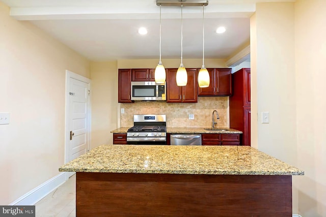 kitchen featuring appliances with stainless steel finishes, decorative light fixtures, decorative backsplash, sink, and light stone countertops