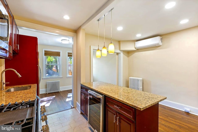 kitchen with radiator heating unit, light stone countertops, wine cooler, sink, and a wall mounted AC