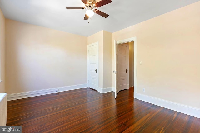 spare room with ceiling fan, dark hardwood / wood-style floors, and radiator