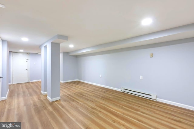 basement with light hardwood / wood-style flooring and a baseboard radiator