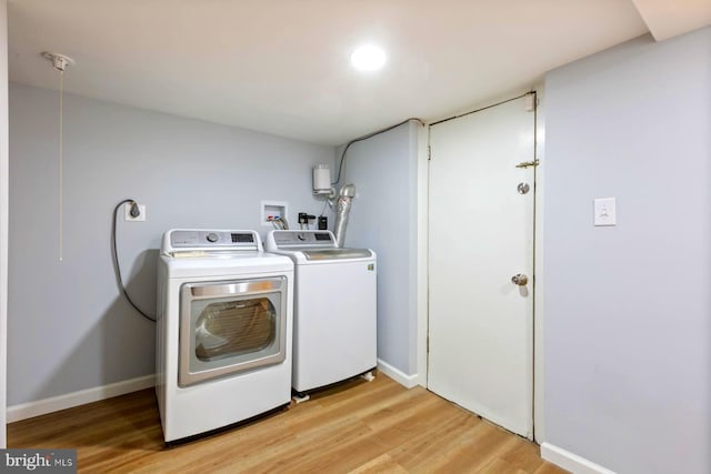 washroom with light hardwood / wood-style floors and washer and clothes dryer