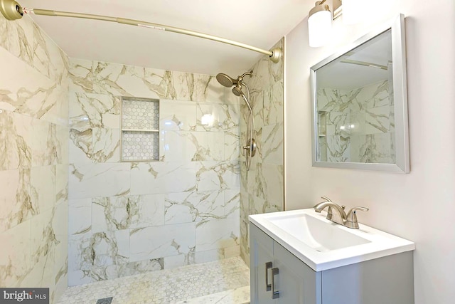 bathroom featuring a tile shower and vanity