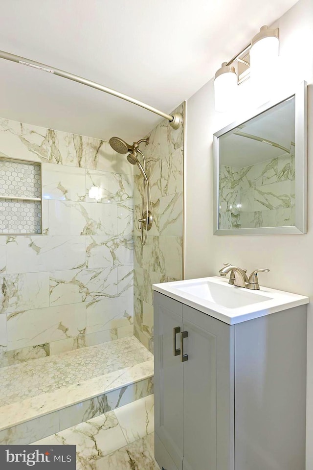 bathroom featuring tiled shower, tile patterned flooring, and vanity