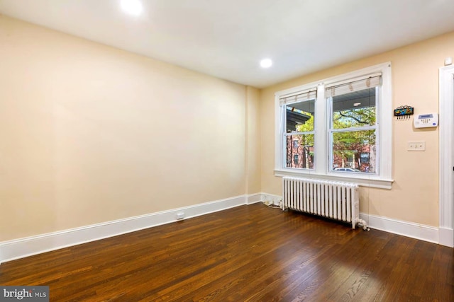 unfurnished room featuring wood-type flooring and radiator heating unit