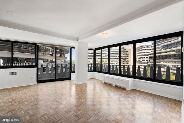 spare room with ornamental molding and parquet floors