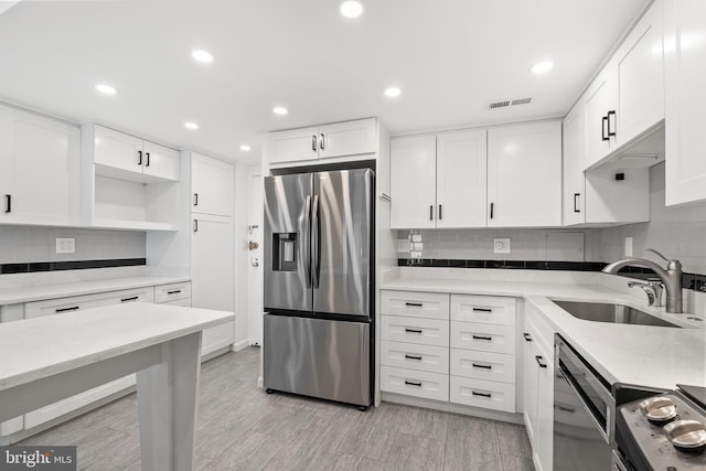 kitchen featuring light wood-type flooring, white cabinets, sink, and stainless steel appliances