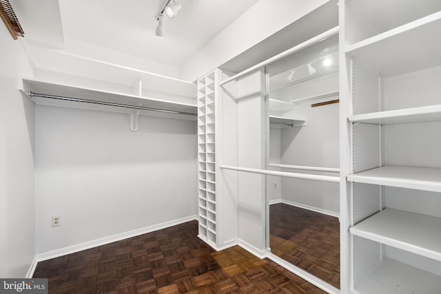 walk in closet featuring dark parquet flooring