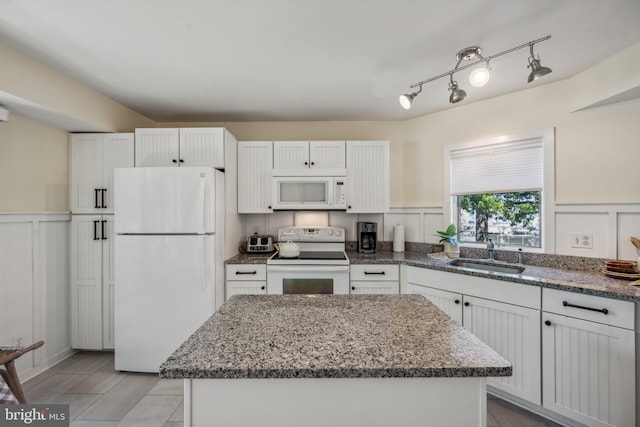 kitchen with a center island, white cabinetry, sink, and white appliances