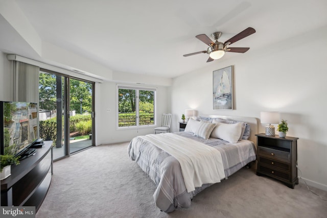 bedroom featuring light carpet, access to exterior, and a ceiling fan