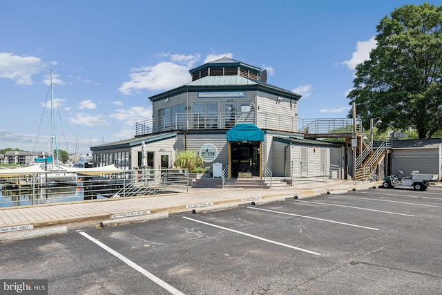 view of building exterior featuring uncovered parking and a water view