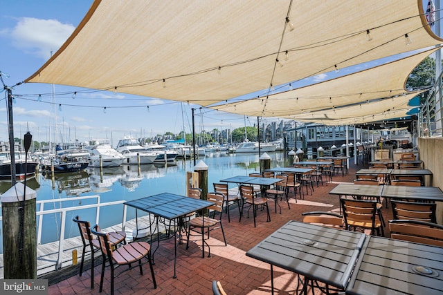 view of dock with a patio and a water view