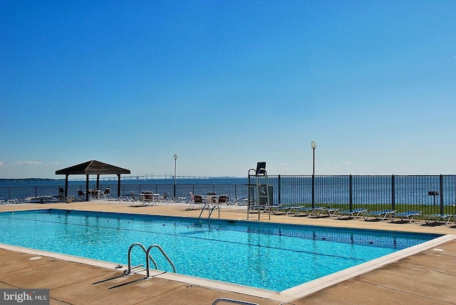 view of swimming pool with a patio area and a water view