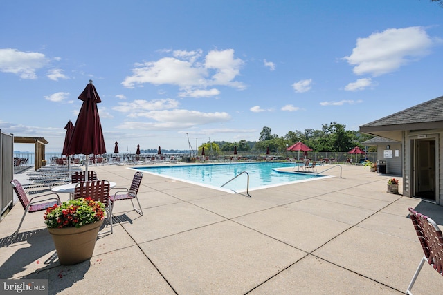 community pool featuring fence and a patio