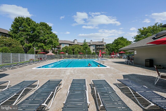 community pool featuring a patio and fence