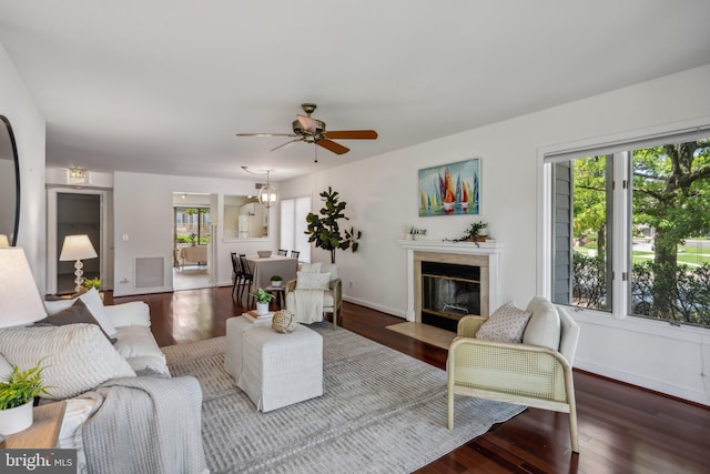 living room featuring a high end fireplace, hardwood / wood-style flooring, and ceiling fan