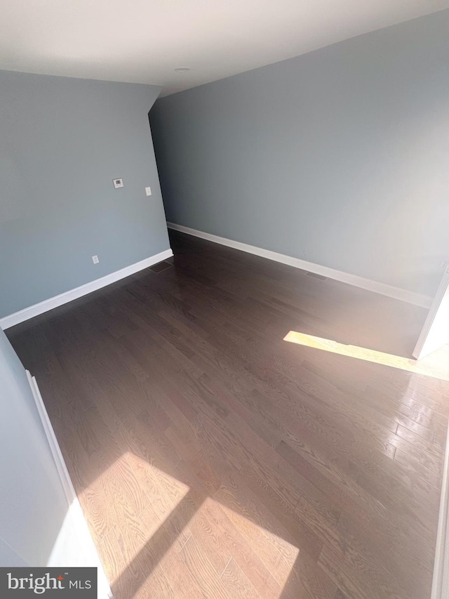 unfurnished room featuring baseboards and wood finished floors