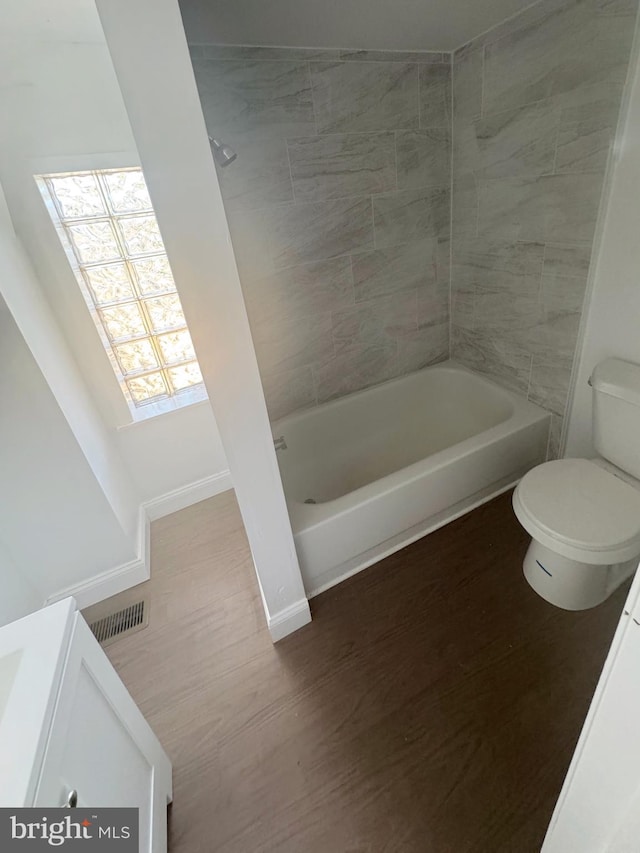 full bathroom featuring tiled shower / bath combo, toilet, and vanity