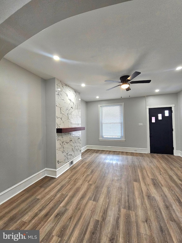 unfurnished living room featuring hardwood / wood-style floors, ceiling fan, and a textured ceiling