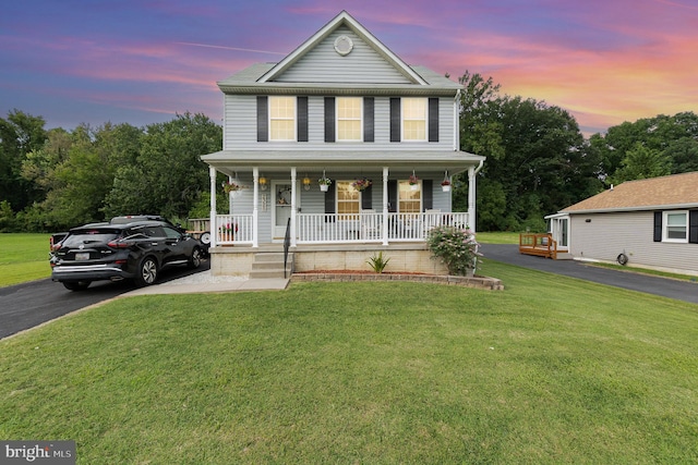 view of front of property featuring a porch and a lawn