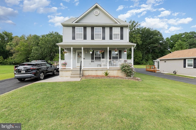 view of front facade with driveway, covered porch, and a front lawn