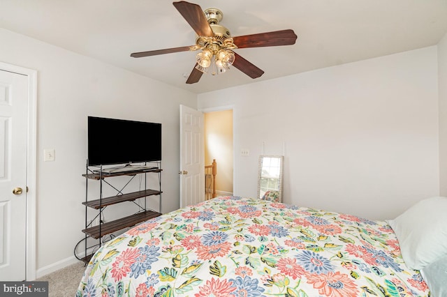 carpeted bedroom with ceiling fan and baseboards