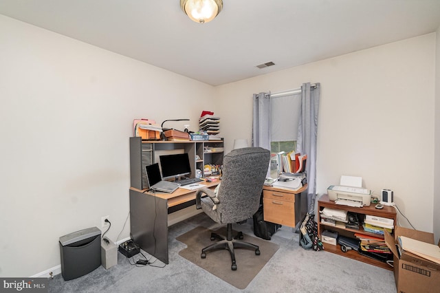 office space with baseboards, visible vents, and light colored carpet