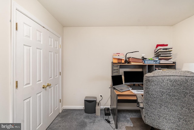 home office with dark colored carpet and baseboards