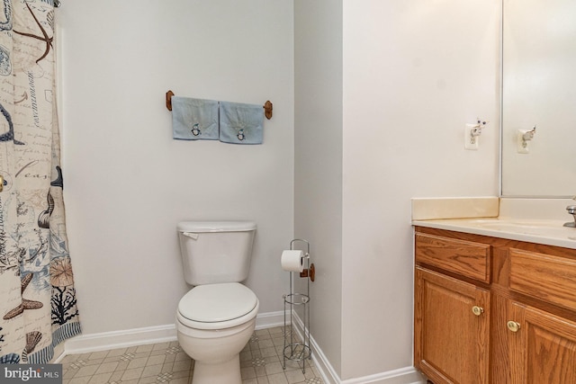 full bath featuring baseboards, vanity, and toilet