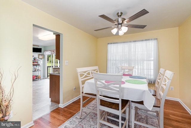 dining room with ceiling fan, wood finished floors, and baseboards