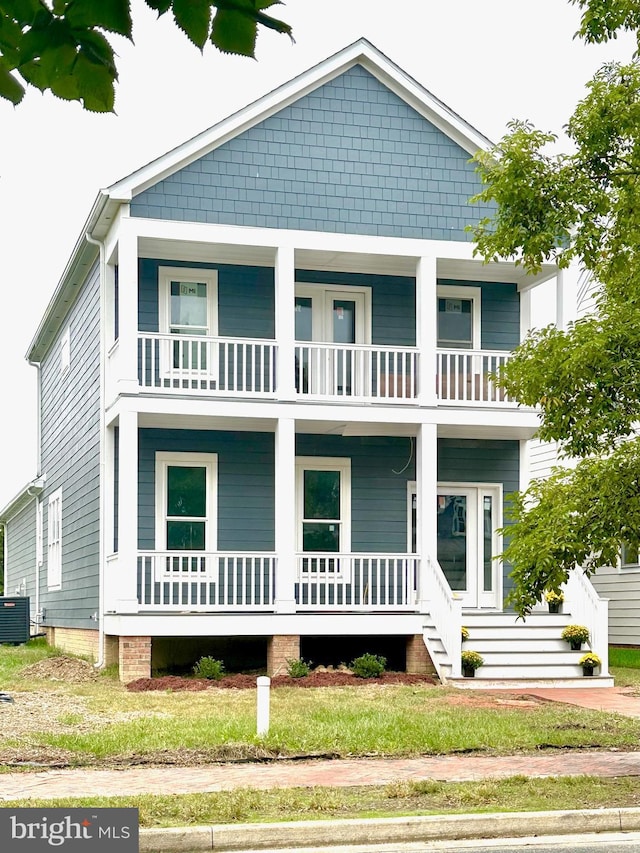 view of front of home with covered porch, central AC, and a balcony